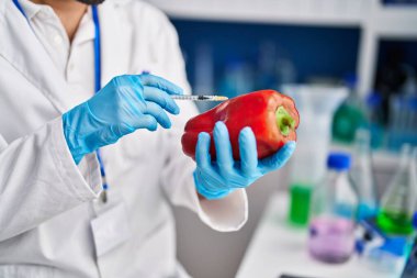 Genç İspanyol bilim adamı laboratuvarda kırmızı biberi analiz ediyor.