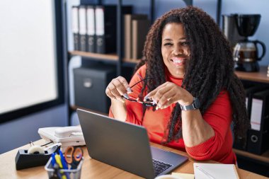 Ofiste çalışırken dizüstü bilgisayar kullanan Afrikalı Amerikalı iş kadını.
