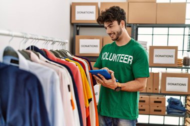 Yardım merkezinde dokunmatik ped kullanan gönüllü üniformalı bir İspanyol genç.