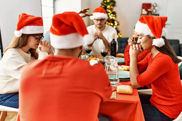 クリスマスを祝う若者のグループ自宅でテーブルの上に座って食べ物を祈る — ストック写真