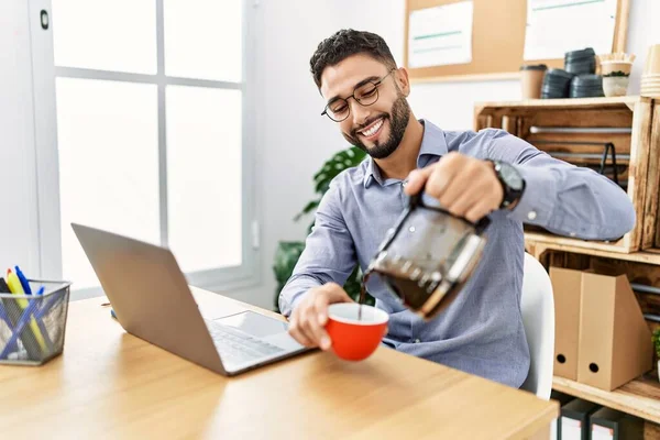 Młody Arabski Człowiek Uśmiechnięty Pewny Siebie Pijący Kawę Pracujący Biurze — Zdjęcie stockowe