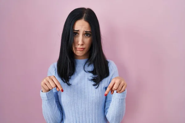 Hispanic Woman Standing Pink Background Pointing Looking Sad Upset Indicating — Zdjęcie stockowe