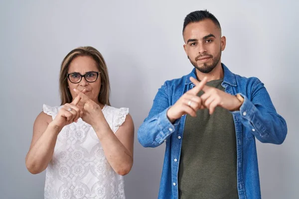 西班牙裔母亲和儿子站在一起 用手指表示拒绝 做阴性手势 — 图库照片