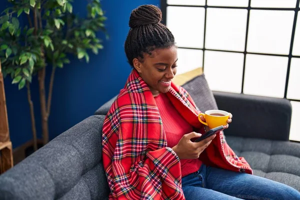 African American Woman Drinking Coffee Using Smartphone Home — ストック写真