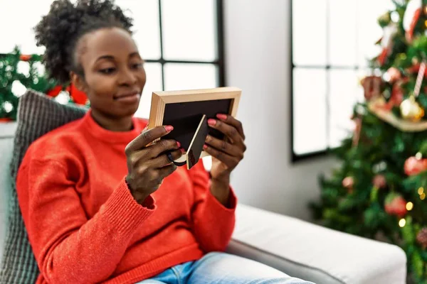 Mujer Afroamericana Mirando Foto Sentada Sofá Por Árbol Navidad Casa —  Fotos de Stock