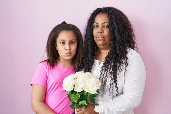 Madre Hija Joven Sosteniendo Ramo Flores Blancas Mirando Cámara Soplando —  Fotos de Stock