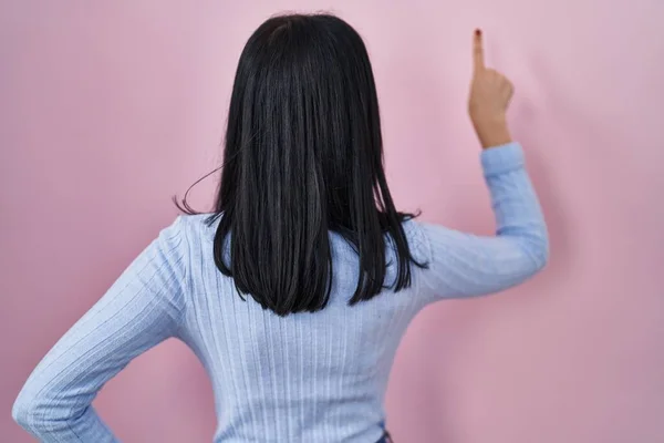Hispanic Woman Standing Pink Background Posing Backwards Pointing Ahead Finger — Stock Photo, Image
