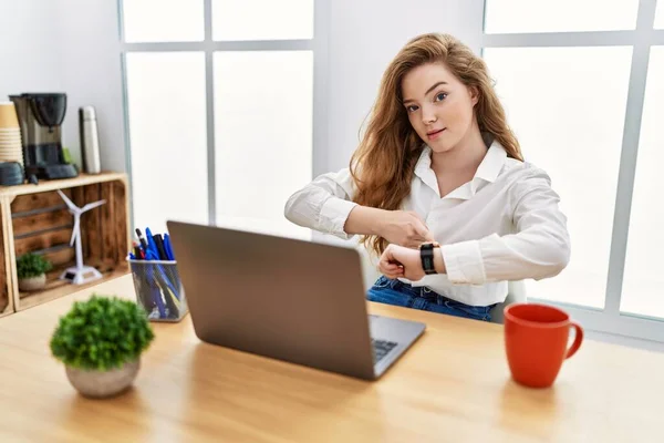 若い白人女性がオフィスで働いていますコンピュータのラップトップを使用して急いで時間を見て 動揺し 期限遅れに怒っています — ストック写真