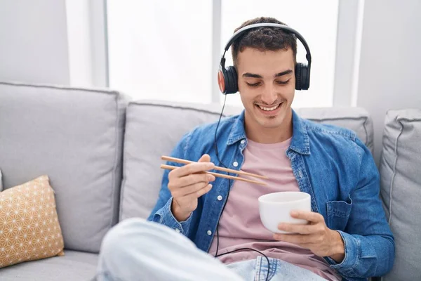 Молодий Іспаномовний Чоловік Слухає Музику Їсть Китайську Їжу Вдома — стокове фото