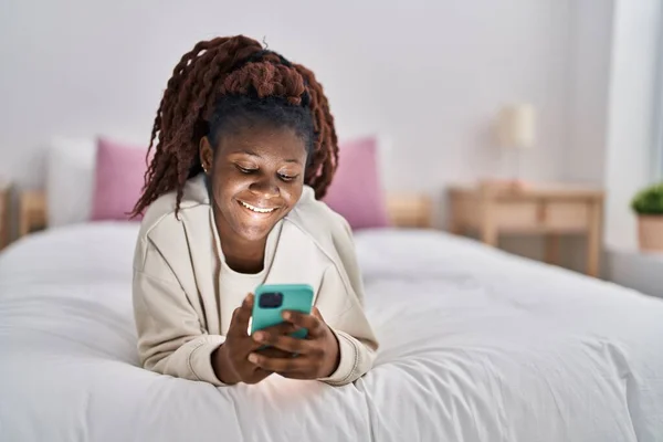 African American Woman Using Smartphone Lying Bed Bedroom – stockfoto