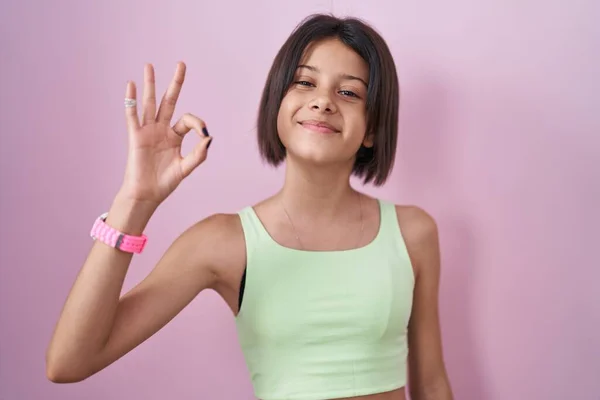 Giovane Ragazza Piedi Sfondo Rosa Sorridente Positivo Facendo Segno Con — Foto Stock