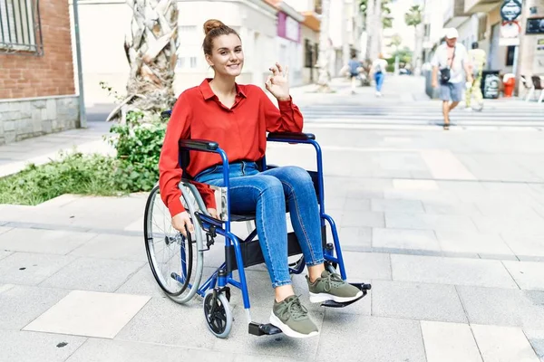 Tekerlekli Sandalyede Oturan Genç Esmer Kadın Parmaklarıyla Imza Atıyor Gülümseyerek — Stok fotoğraf