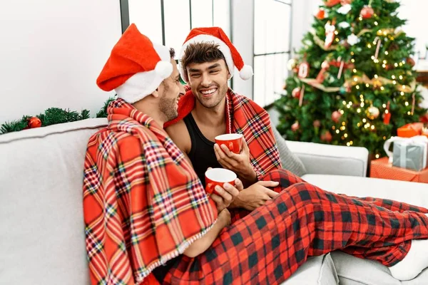 二つのヒスパニック系男性カップル飲むコーヒーによってクリスマスツリーに家 — ストック写真