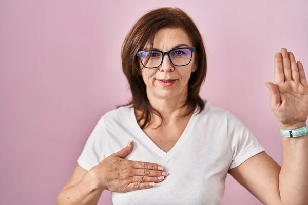 Middle Age Hispanic Woman Standing Pink Background Swearing Hand Chest — Stock Photo, Image