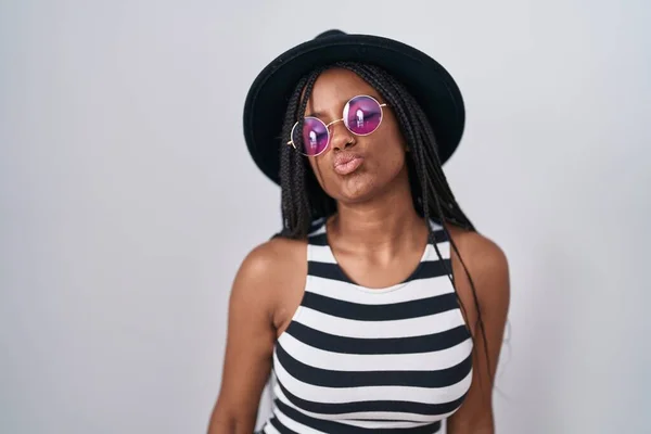 Молодой Африканский Американец Косичками Шляпе Солнцезащитных Очках Смотрящий Камеру Дующий — стоковое фото