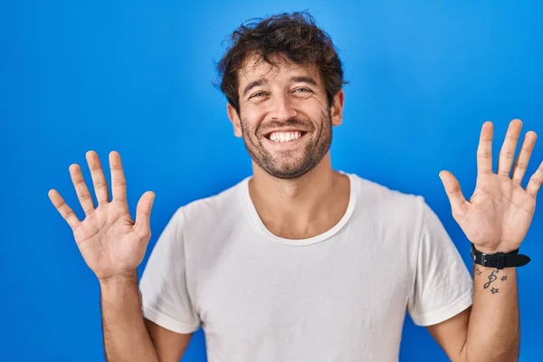 Spanischer Junger Mann Steht Vor Blauem Hintergrund Und Zeigt Mit — Stockfoto