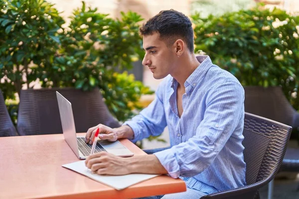 Νεαρός Ισπανόφωνος Που Χρησιμοποιεί Laptop Γράφοντας Χαρτί Καθισμένος Στο Τραπέζι — Φωτογραφία Αρχείου