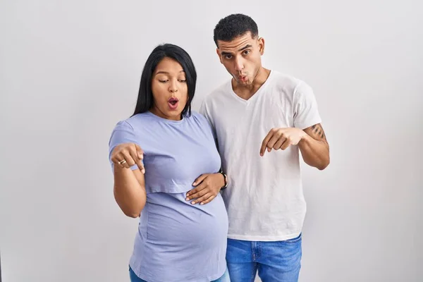 Jovem Casal Hispânico Esperando Bebê Sobre Fundo Apontando Para Baixo — Fotografia de Stock
