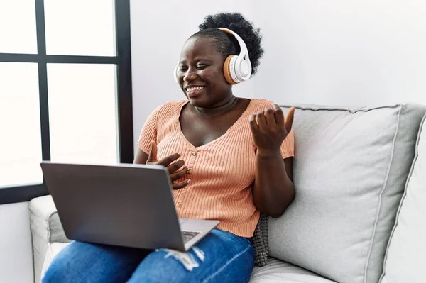 Young African American Woman Listening Music Sitting Sofa Home — ストック写真