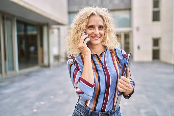 Middelaldrende Blond Kvinne Som Snakker Smarttelefonen Med Skriveplate Gaten – stockfoto