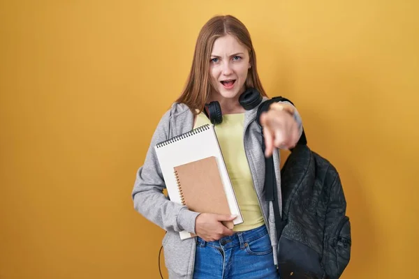 Young Caucasian Woman Wearing Student Backpack Holding Books Pointing Displeased — 图库照片