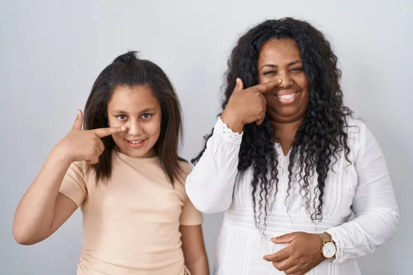 母親と若い娘の白い背景の顔と鼻に手の指を指して立って 陽気な笑顔 美の概念 — ストック写真