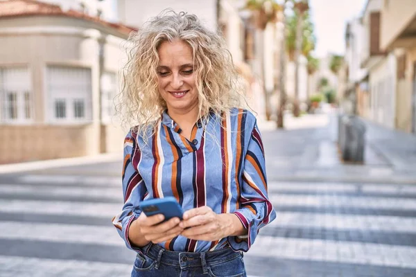 Blonde Frau Mittleren Alters Lächelt Selbstbewusst Mit Smartphone Auf Der — Stockfoto