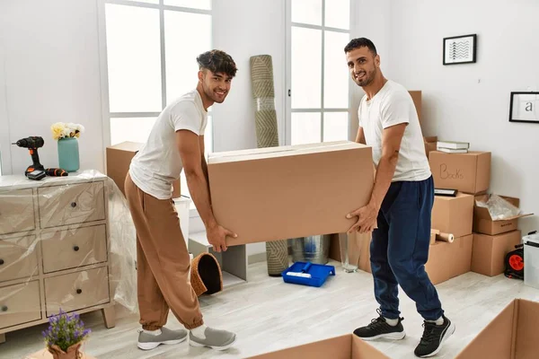 Dos Hombres Hispanos Pareja Sonriendo Confiados Sosteniendo Caja Cartón Nuevo — Foto de Stock
