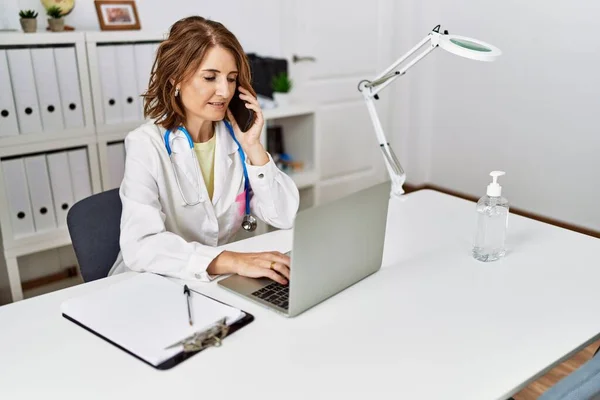 Middle Age Hispanic Woman Wearing Doctor Uniform Talking Smartphone Clinic — Stock Photo, Image