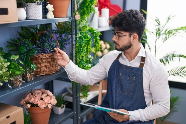 Jonge Spaanse Man Bloemist Schrijven Notebook Zoek Planken Bij Bloemist — Stockfoto