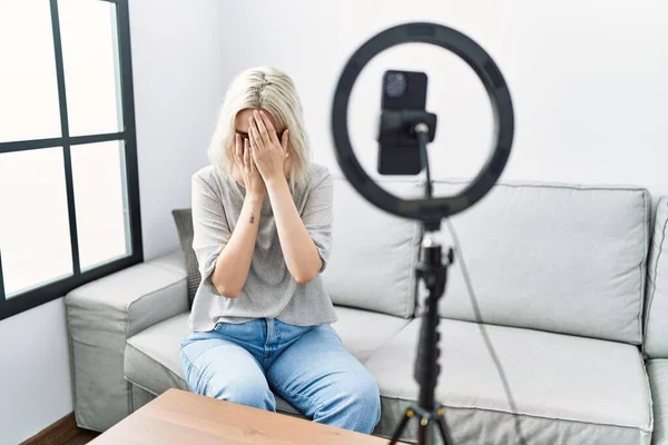 泣きながら手で顔を覆い悲しい表情で自宅でスマートフォンでVlogチュートリアルを記録若い白人女性 うつ病の概念 — ストック写真