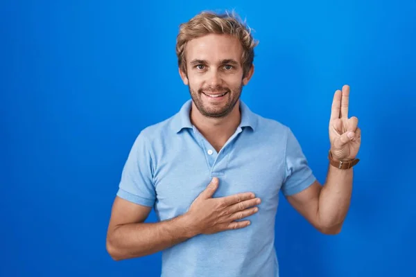 Caucasian Man Standing Blue Background Smiling Swearing Hand Chest Fingers — Stockfoto