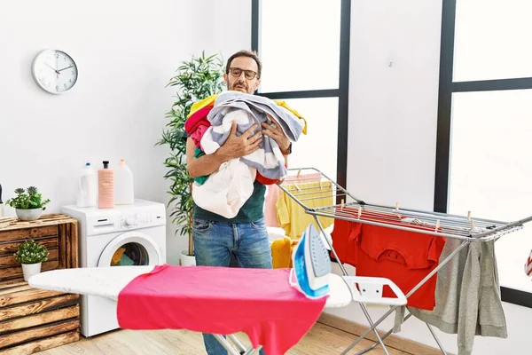 Hombre Hispano Mediana Edad Haciendo Quehaceres Domésticos Sosteniendo Ropa Casa — Foto de Stock