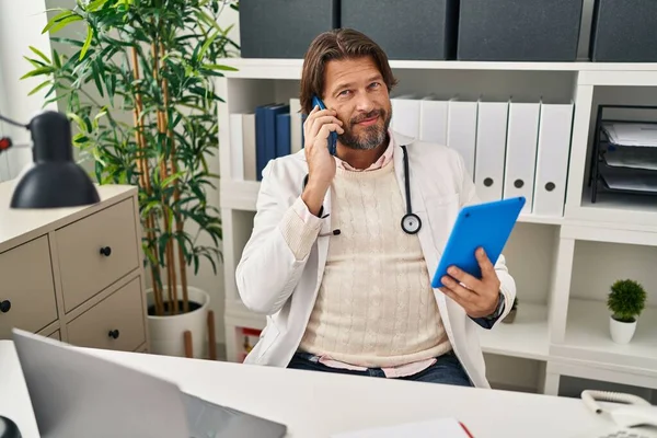 Médico Meia Idade Falando Smartphone Usando Touchpad Clínica — Fotografia de Stock