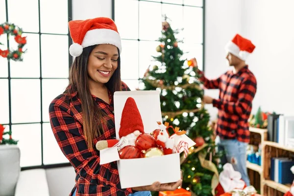 若いですラテンカップル笑顔幸せな飾るクリスマスツリーにホーム — ストック写真