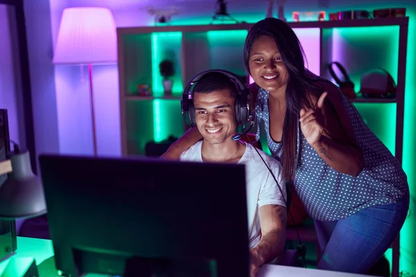 Mladý Hispánský Pár Hraje Videohry Úsměvem Šťastný Ukazování Rukou Prstem — Stock fotografie
