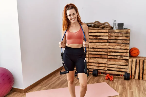 Mujer Pelirroja Joven Entrenando Con Brazaletes Elásticos Sonriendo Con Una —  Fotos de Stock