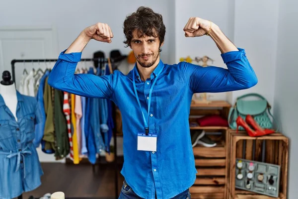 Young Hispanic Man Working Manager Retail Boutique Showing Arms Muscles — Stockfoto