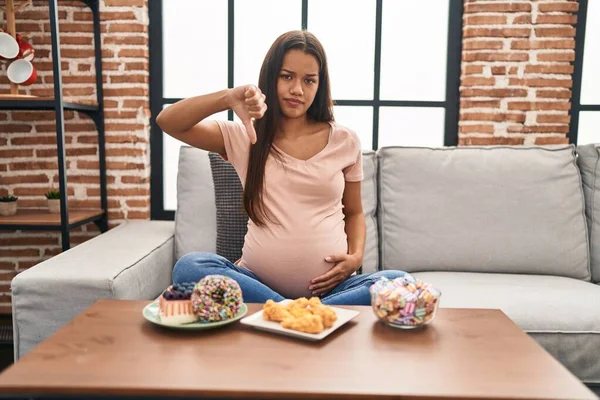 Mujer Embarazada Joven Comiendo Dulces Casa Con Cara Enojada Signo —  Fotos de Stock