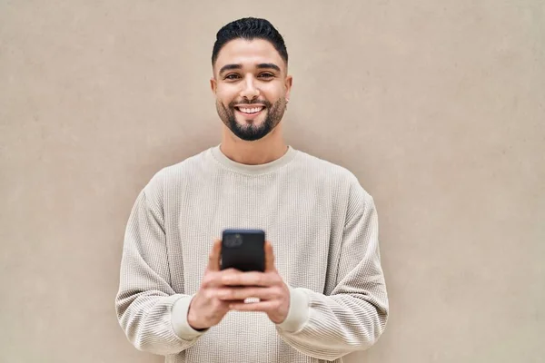 아라파 청년은 스마트폰을 사용하여 자신있게 웃는다 — 스톡 사진