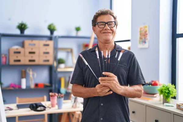 Middle Age Man Artist Smiling Confident Holding Paintbrushes Art Studio — ストック写真