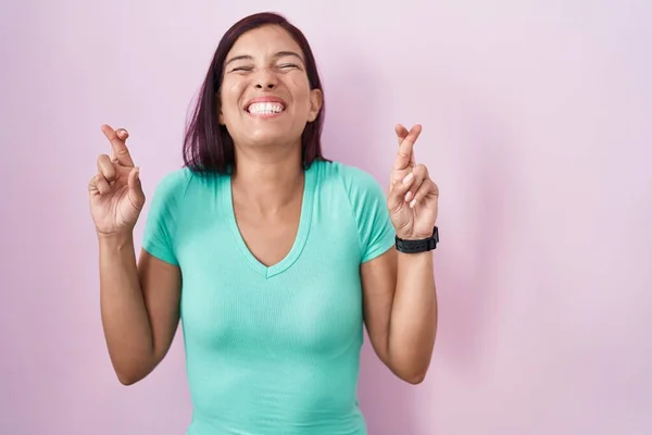 Mujer Hispana Joven Pie Sobre Fondo Rosa Gesto Dedo Cruzó —  Fotos de Stock