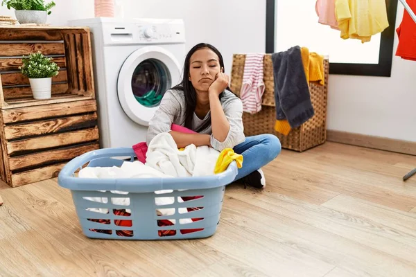 若いですラテン女性退屈待っていますのために洗濯機でランドリールーム — ストック写真
