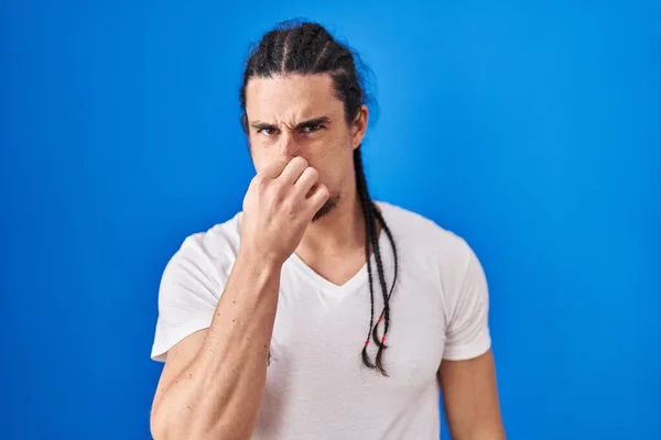 Hispanic Man Long Hair Standing Blue Background Smelling Something Stinky — ストック写真