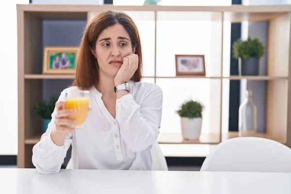 Brunette Vrouw Die Een Glas Sinaasappelsap Drinkt Gestrest Nerveus Uitziet — Stockfoto