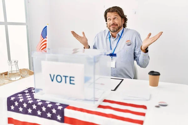 一个英俊的中年男人坐在投票站里 面色苍白 双手高举 毫无头绪 怀疑概念 — 图库照片