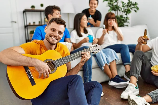 파티에 친구들 행복하게 집에서 클래식 기타를 연주하는 — 스톡 사진