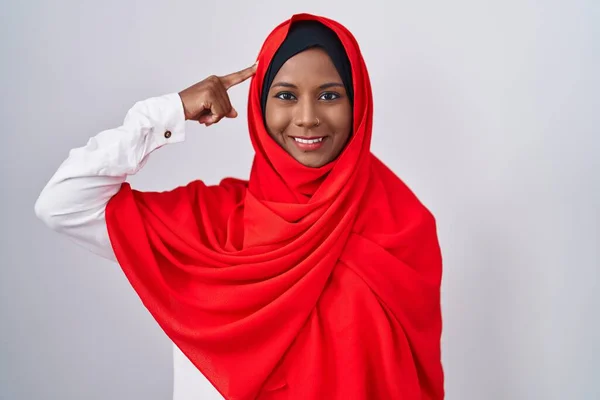 伝統的なイスラム教のヒジャーブスカーフを身に着けている若いアラブの女性は 1本の指で頭を指して笑顔 素晴らしいアイデアや考え 良い思い出 — ストック写真