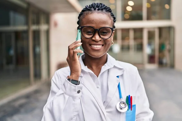 African American Woman Doctor Smiling Confident Talking Smartphone Hospital — Stockfoto