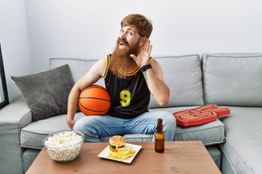 Uzun sakallı, basketbol topu tutan beyaz bir adam televizyon oyunu tezahüratı yapıyor. Kulaktan kulağa gülümsüyor. Dedikoduları ve dedikoduları dinliyor. Sağırlık kavramı. 